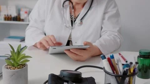 Doctor using technology to consult people remotely on tablet. Stock Footage 299633171