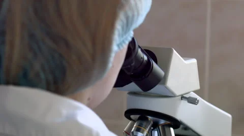Doctor viewing through microscope Vidéo 52060997