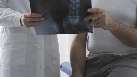 Doctor visiting a patient and checking a radiograph Stock Footage 127365650