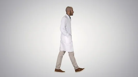 Doctor walking with hands in pockets on gradient background. Stock-Footage 114696249