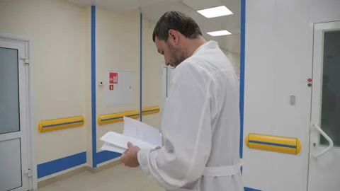 The doctor walks down the corridor with documents Видео 92331365