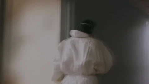 A doctor walks down the hall in a protective suit after heavy duty Stock Footage 133391901