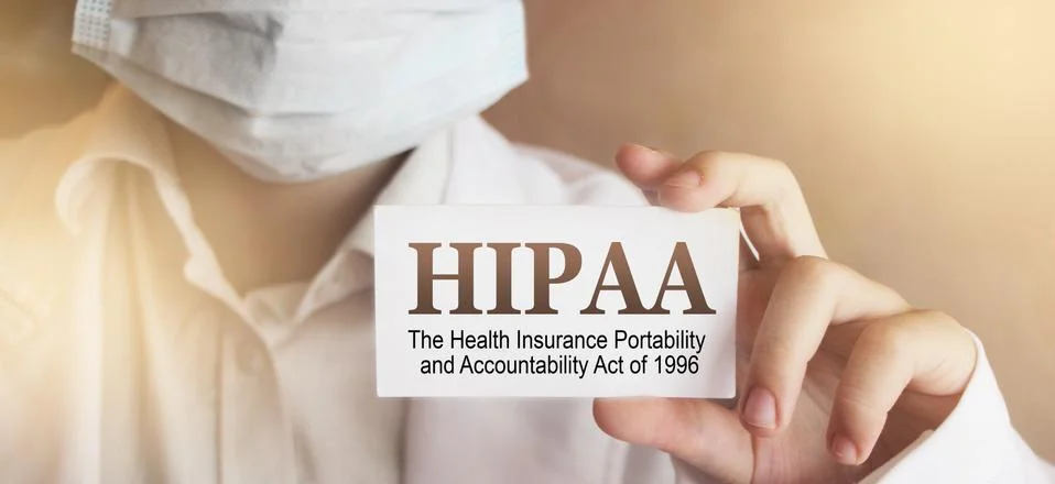 Doctor wearing face mask shows a card with the text HIPPA, The Health Insuran Stock Photos