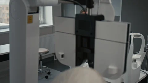 Doctor Wearing Lab Coat Setting Up Diagnostic Machine For Eye Test Stock Footage 322693079