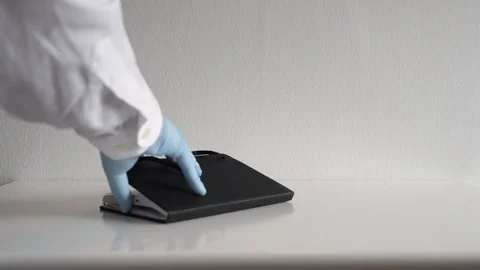Doctor wearing plastic gloves writing on his notebook Vídeo Stock 128456341