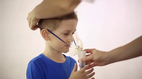 The doctor wears a mask inhaler on the patient's head Stock Footage 79841653