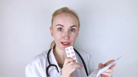 The doctor on a white background reads the instructions for medicines. The speci Video stock 150354720