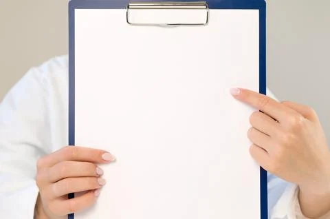 A doctor in a white coat points to an empty space on a paper. The doctor is h Stock Photos