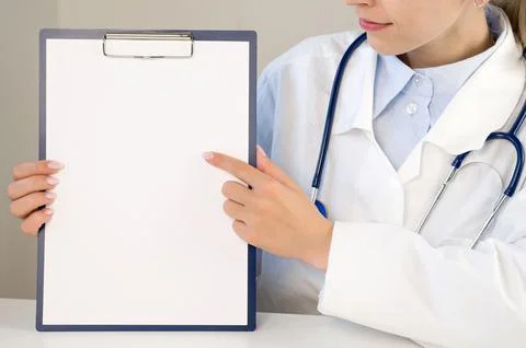 A doctor in a white coat points to an empty space on a paper. The doctor is h Stock Photos