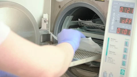 The doctor will put dental instruments for sterilization in a steam autoclave Video stock 104509391