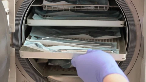 The doctor will put dental instruments for sterilization in a steam autoclave Stock Footage 104509439