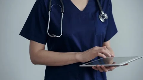 Doctor woman is using tablet computer while standing in medical office in clinic Stock Footage 243076848