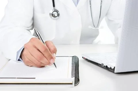 Doctor at work writng notes by the desk Stock Photos