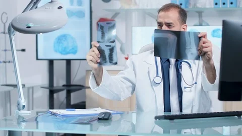Doctor working in his office, analyzing X rays scans Stock Footage 108536059