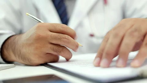 The doctor is working on the paperwork, he checks the patient's condition, check Stock Footage 160946368