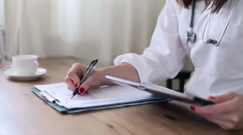 Doctor working with tablet computer and documents HD Stock Footage 25239581