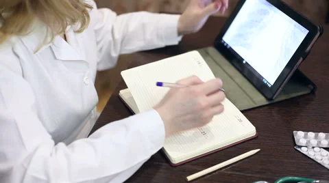 Doctor working with tablet computer and documents Stock Footage