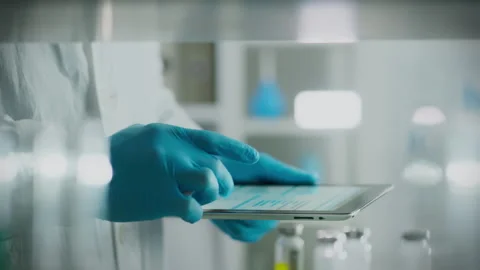 The doctor works intently with a touchscreen tablet, entering data about the Stock Footage 263624728
