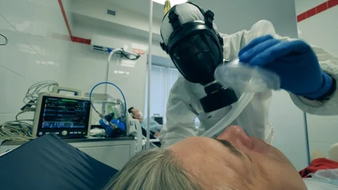 Doctor works with ventilator while treating man with coronavirus. Video stock 128302378