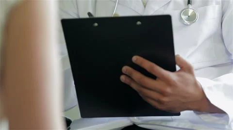 The doctor writes his observations at the reception Stock Footage 44232813