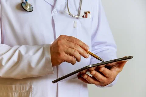 The doctor writes notes on a tablet on the clipboard at the hospital Stock Photos