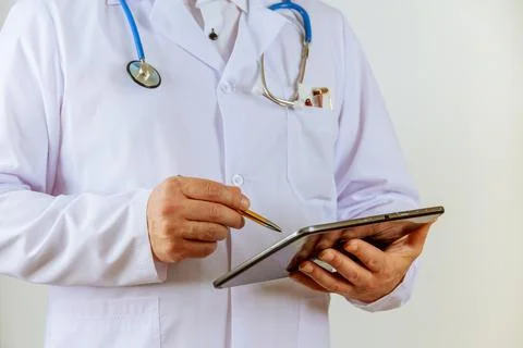 The doctor writes notes on a tablet on the clipboard at the hospital. Prescri Stock Photos