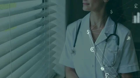 Doctor writing notes by blinds, causing animated $€£ icons and charts aiding Stock Footage 330238013