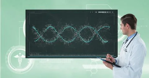 Doctor writing notes while looking at DNA structure Foto stock