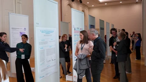 Doctoral Researcher Explaining Poster to Attendees at Scientific Conference Stock Footage 334776457