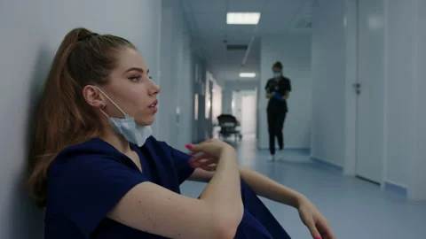 Doctors after surgery are sitting tired in the corridor of the hospital Stock Footage 208004987