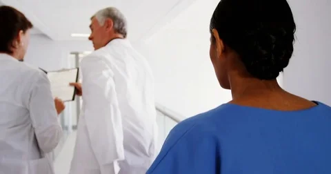 Doctors and nurse running in passageway of hospital Stock Footage