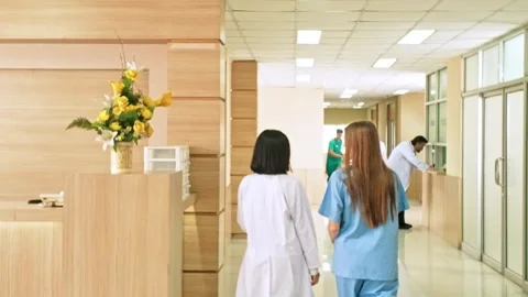 Doctors and nurses rush patient on stretcher through hospital corridor Stock Footage 315160199