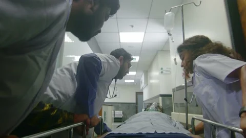Doctors and nurses rushing a critical patient on stretcher to operation theatre Stock Footage 233786555