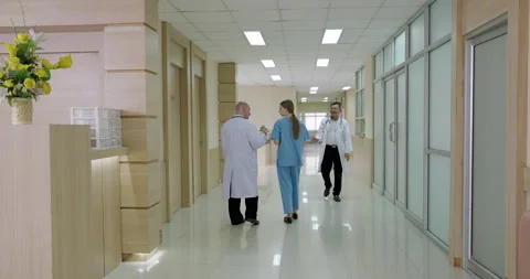 Doctors and nurses walking inside hospital corridor during busy work shift Stock Footage 314002289