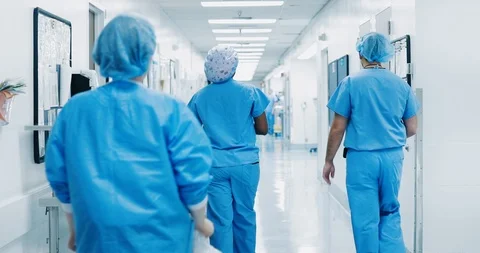 Doctors and surgeons walking down hospital corridor Stock Footage 127111909