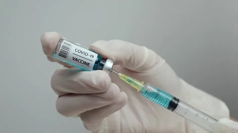 Doctors are preparing a Covid-19 vaccine from a small bottle and syringe. Stock Footage 135712654