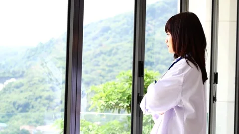 Doctors are standing looking through the window and thinking of something. Stock Footage 79609585