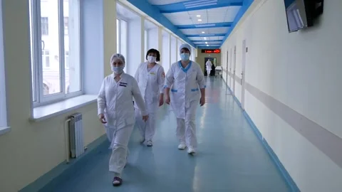 Doctors are walking down the corridor, they are in a hurry for an operation. Stock Footage 167833376