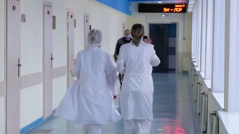 Doctors are walking down the corridor, they are in a hurry for an operation. Stock Footage 167833420