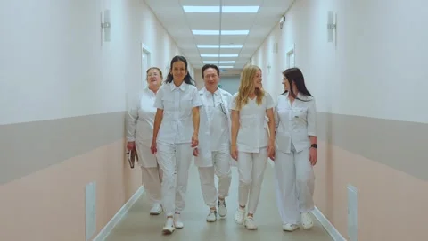 The doctors are walking down the corridor, the doctors are smiling 스톡 동영상 314312830