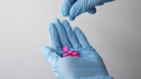 The doctor's blue-gloved hand holds a tablet. Stock Footage 127217789