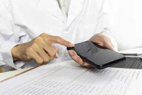 Doctors check medical information using a mobile app. Stock Photos