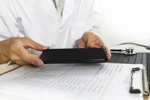 Doctors check medical information using a mobile app. Stock Photos