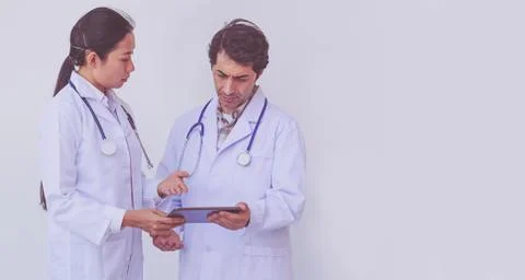 Doctors checking patient information on a tablet device Stock Photos