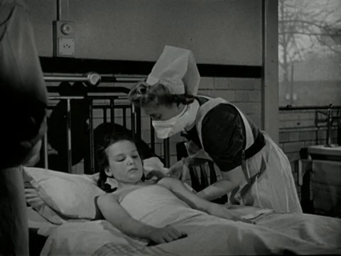 Doctors checking up on young ill girl, talking about advancing disease, UK 1947 Video stock 134033735