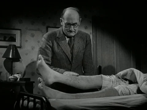Doctors checking up on young ill man, trying to come to a diagnosis, UK 1947 Stock Footage 134033129