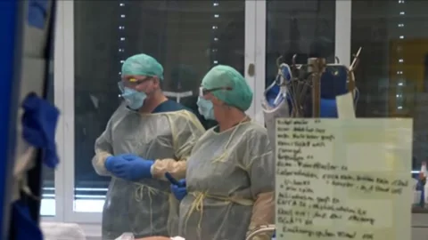 Doctors communicate near a seriously ill patient. Under box ventilation Stock Footage 133536030