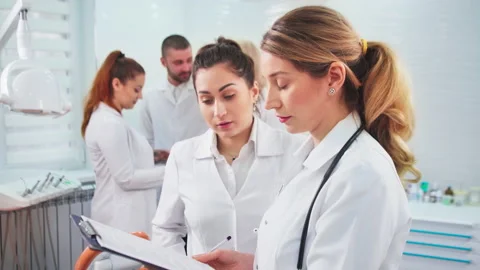 Doctors in the dental office. Talking nurses and one noting doctor Stock Footage 154349818
