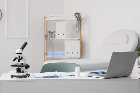 Doctor's desk with laptop and microscope in medical office Фото