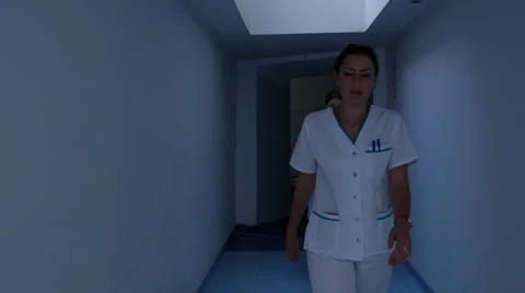 Doctors discuss a patient's notes as they walk down a hospital corridor Video stock 68684241